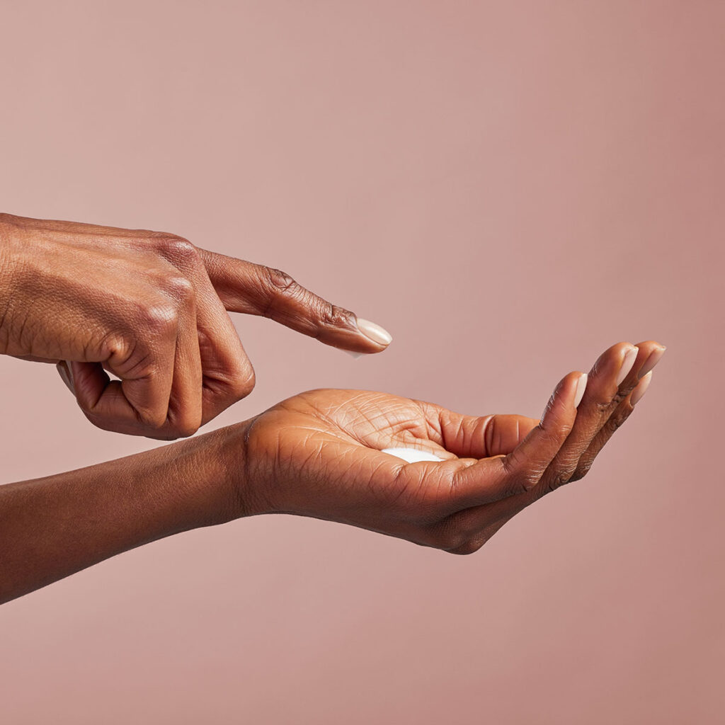 Hands applying cream